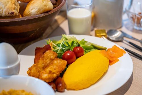 a plate of food on a table with a plate of food at Holiday Inn Resort Shinano-Omachi Kuroyon by IHG in Omachi