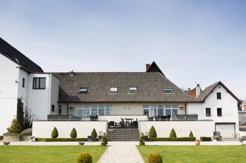 a white house with a black roof at Hotel Malpertuus in Riemst