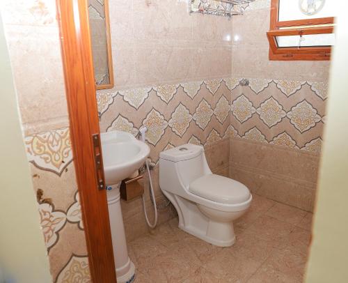 ein Bad mit einem WC und einem Waschbecken in der Unterkunft Nima guest house in Nizwa