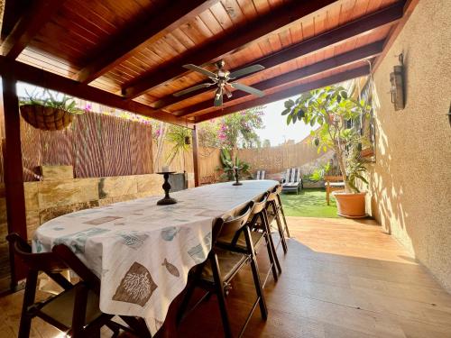 een eettafel met stoelen en een plafondventilator bij BUNGALOW DE LUJO en PLAYA SAN JUAN in El Campello