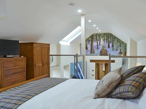 1 dormitorio con 1 cama con una pintura en la pared en Bluebell Barn, en Okehampton