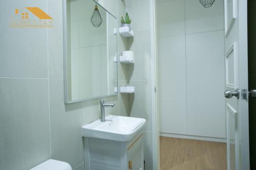 W białej łazience znajduje się umywalka i lustro. w obiekcie Legasi Kampung Baru by Twenty7 w Kuala Lumpur