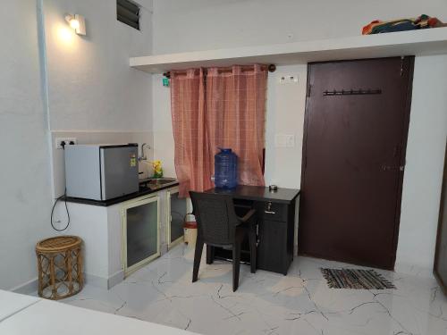 a small kitchen with a table and a microwave at Mysore Studio Rooms in Mysore