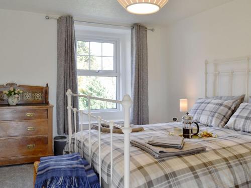 1 dormitorio con 1 cama con tocador y ventana en Apple Tree Cottage, en Bassenthwaite