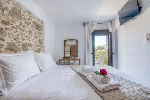 a bedroom with a white bed with towels and a window at Pool Villa Michail, in Kissamos! in Koukounará