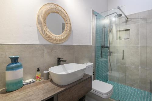 La salle de bains est pourvue d'un lavabo, de toilettes et d'un miroir. dans l'établissement San Lameer Villa 3107 - 4 Bedroom Classic - 8 pax - San Lameer Rental Agency, à Southbroom