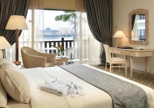 Habitación de hotel con cama, escritorio y ventana en Mines Beach Resort Hotel, en Seri Kembangan