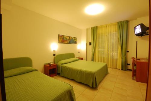 Habitación de hotel con 2 camas y TV en Park Hotel & Dependance, en Martinsicuro