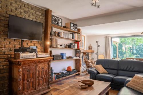 a living room with a tv on a brick wall at Holiday home Keysersnest in Gistel