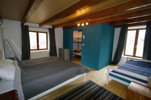 ein Schlafzimmer mit einem Bett und einer blauen Wand in der Unterkunft Le Bourdon bleu à Celles en Bassigny in Celles-en-Bassigny