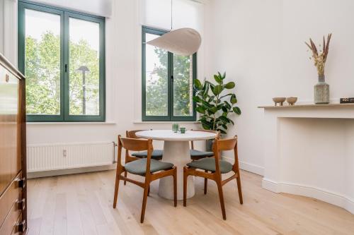 une salle à manger blanche avec une table et des chaises dans l'établissement Quartier Le Sud, à Anvers