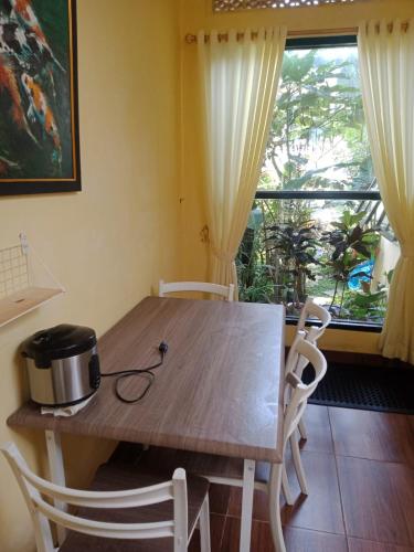 a dining room table with chairs and a window at Villa kota bunga 3 kamar bersih dan terawat in Cikundul