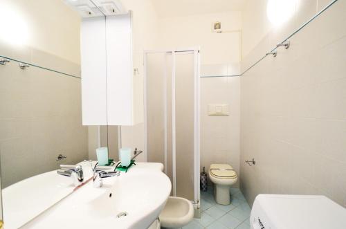 bagno bianco con lavandino e servizi igienici di Magica Immobiliare - Doge 22 a Lido di Jesolo
