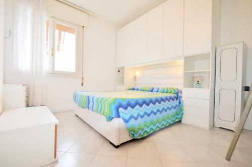 een witte slaapkamer met een groot bed en witte kasten bij Magica Immobiliare - Doge 22 in Lido di Jesolo