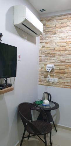 a room with a table and a television and a chair at 56 HOTEL in Mentekab