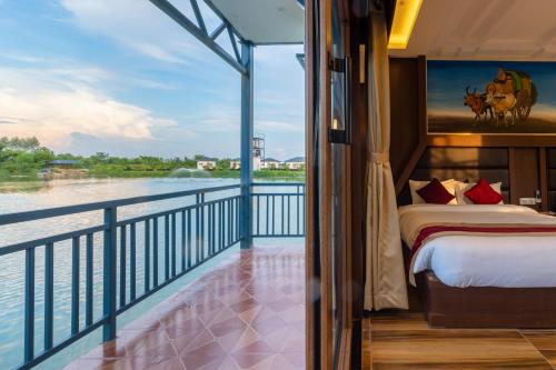 a balcony with a bed and a view of the water at Lumbini Palace Resort in Lumbini