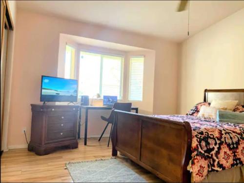 1 dormitorio con 1 cama y escritorio con ordenador en Countryside Colt Suite with private bathroom, en Hemet