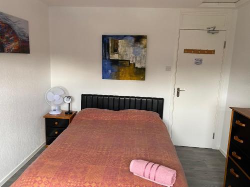 a bedroom with a bed with a red bedspread at Quiet, spacious double bedroom! in Peterborough