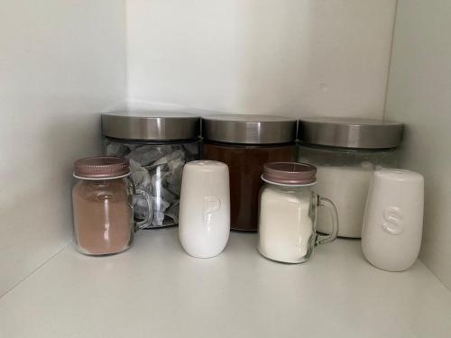 a shelf with three jars of milk and other items at Quiet, spacious double bedroom! in Peterborough