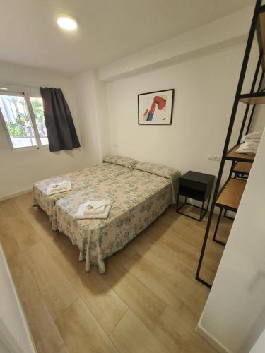 Habitación pequeña con cama y escalera en Apartamentos Maysan, en Benidorm