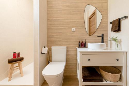 uma casa de banho com um WC, um lavatório e um espelho. em Estilo japandi Sardinero em Santander