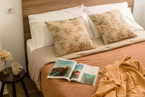 a bed with a book and pillows on it at Estilo japandi Sardinero in Santander