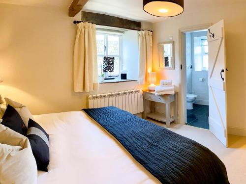 a bedroom with a bed and a desk and a window at The Owlery At Aysgarth in Aysgarth
