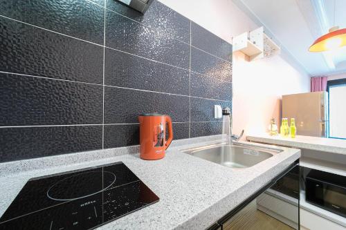 a kitchen with a sink and a counter top at Gangneung Haesolnaeeum Pension in Gangneung