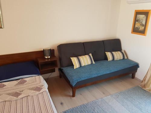 - un canapé avec deux oreillers dans le salon dans l'établissement Apartments Snježana Carev, à Jezera