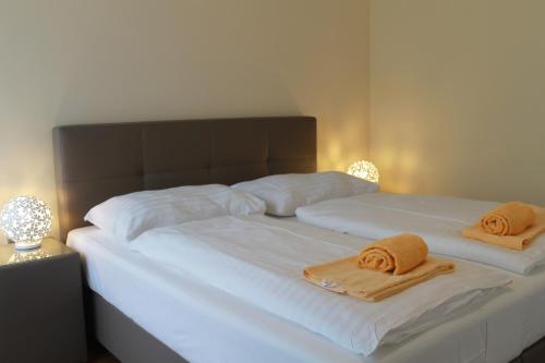 1 cama blanca grande con 2 toallas en Starapartments, en Bad Hofgastein