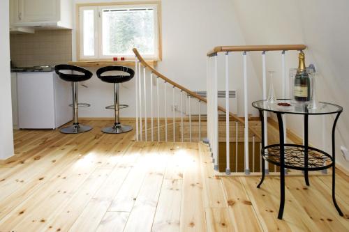 a kitchen with two stools and a table with a bottle of wine at Vohloisten Kartano in Lohja