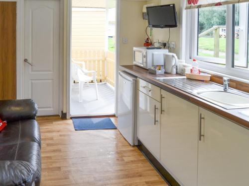 a kitchen with a counter with a sink and a microwave at Maud - Uk12693 in Stalham