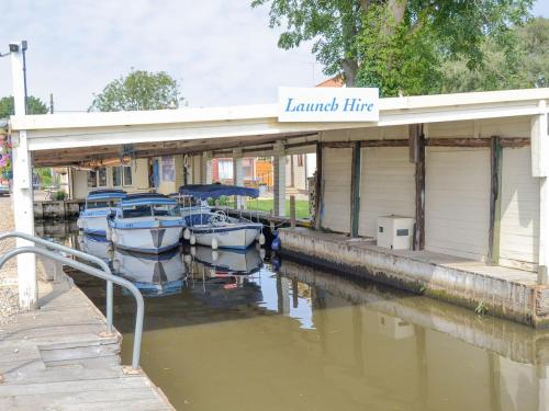 a marina with boats docked next to a building at Maud - Uk12693 in Stalham