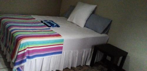 a bed with a colorful blanket and a remote control on it at Waltershort Guest House and Bed and Breakfast in Pietermaritzburg
