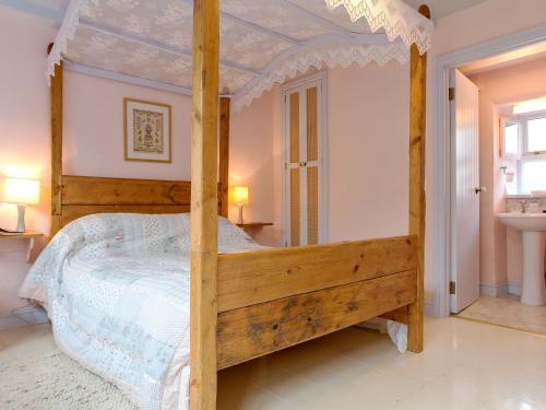 a bedroom with a wooden canopy bed in a room at New England-uk12750 in Menheniot
