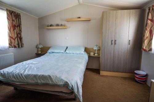 Giường trong phòng chung tại 6 Berth Caravan With Decking And Wifi At Suffolk Sands Holiday Park Ref 45040g