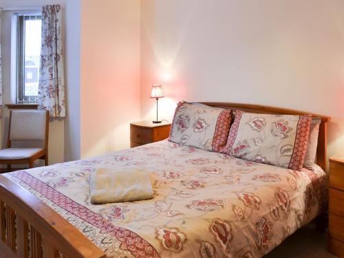a bedroom with a bed with a pillow on it at Glen Apartment in Aviemore