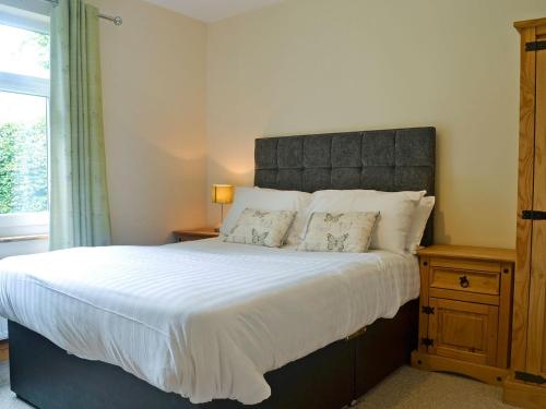 a bedroom with a large bed and a window at Cressfield Villa in Ecclefechan