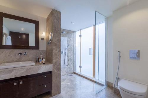 a bathroom with a toilet and a sink and a shower at StayVista at Bella Aquila with Pvt Pool & Lawn - Parra NorthGoa in Anjuna