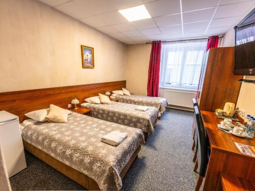 a hotel room with three beds in a room at Byczy Rog noclehy na hranici in Králíky