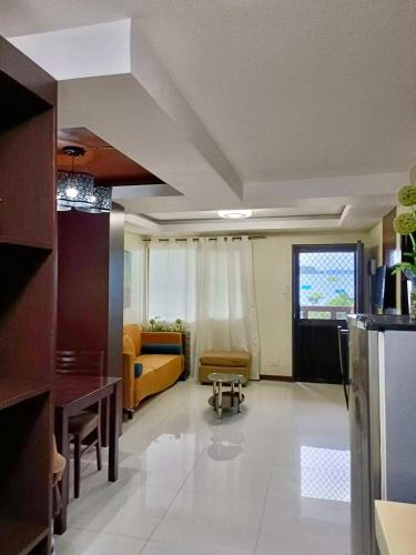 a living room with a yellow couch and a kitchen at Davao 2br One Oasis Beside SM Mall-Wifi in Davao City