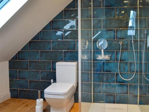 a bathroom with a toilet and a shower at The Hen House At The Old Parsonage in Cote Brook