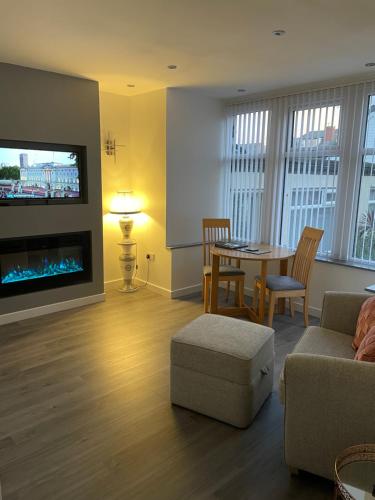 a living room with a couch and a table and a tv at San Remo Apartments Blackpool in Blackpool