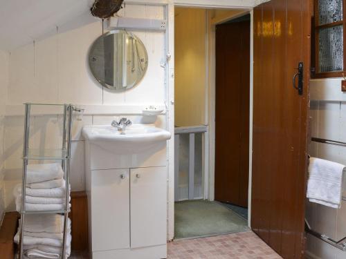 bagno bianco con lavandino e specchio di Ceunant a Aber Cowarch