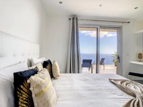 a bedroom with a bed with a view of the ocean at Villa Piece of Heaven by LovelyStay in Estreito da Calheta