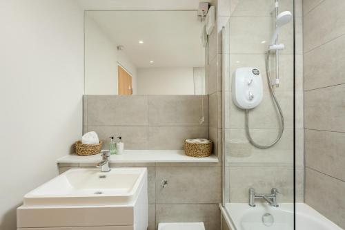 a bathroom with a shower and a toilet and a sink at Modern Mews Apartment - New Town in Edinburgh