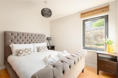 a bedroom with a large bed and a window at Modern Mews Apartment - New Town in Edinburgh