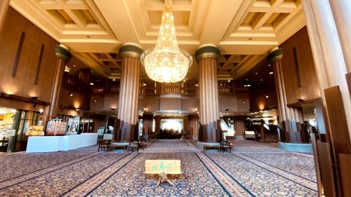 a large lobby with a chandelier and tables in it at Hotel Morinokaze Oshuku in Shizukuishi