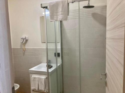 a bathroom with a glass shower with a sink at Pigneto Square Home in Rome
