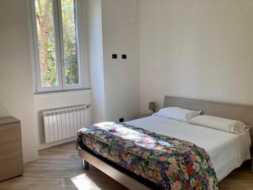 a bedroom with a bed with a floral blanket on it at Pigneto Square Home in Rome